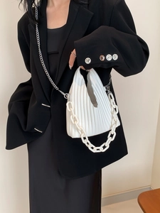 Chic white pleated PU crossbody bag with resin and metal chain straps on a black blazer