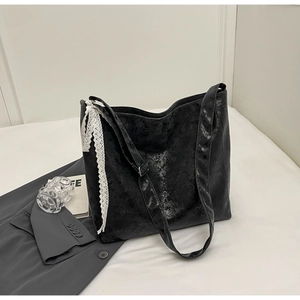 Detail of black tote bag with vintage texture and white lace bow decoration