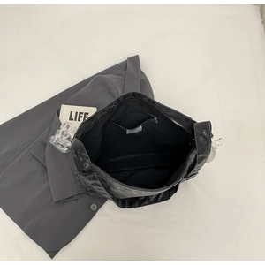 Detail view of large black bucket bag showing spacious interior and textured retro surface