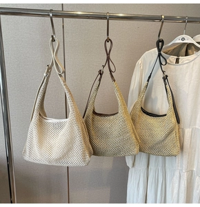 Detail of woven straw shoulder bags in cream, light brown, and dark brown colors