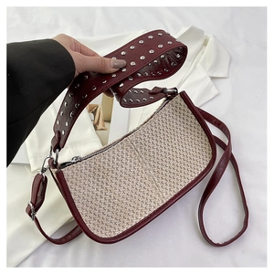 Détail du sac croissant tissé avec bandoulière bordeaux et finitions à rivets argentés