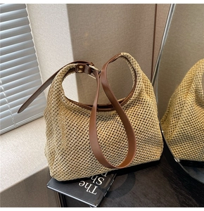 Detail of woven mesh beach bag with brown faux leather strap and golden hardware
