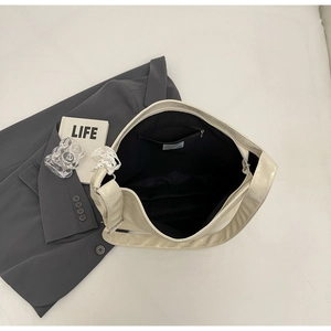 Detailed interior of creamy white bucket bag showing black lining and zip pocket