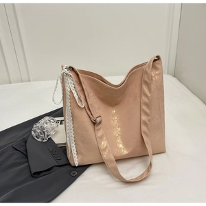 Detail of soft pink bucket bag with delicate white lace ribbon and metallic texture