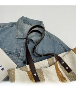 Detail of durable canvas tote with khaki stripes and brown leather shoulder straps