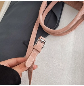 Detailed close-up of glossy pink leather texture and silver buckle on a stylish handbag