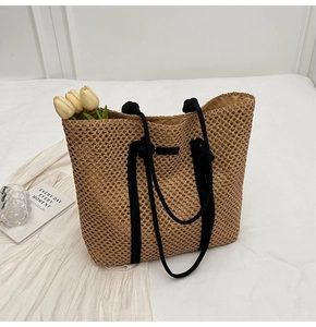 Close-up of khaki hollow woven tote bag with black rope handles and spacious interior