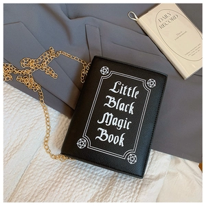 Detail of book-shaped black crossbody bag with Little Black Magic Book print and gold chain