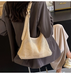 Detail of hand-woven beige tote bag with adjustable leather strap and golden metal buckle