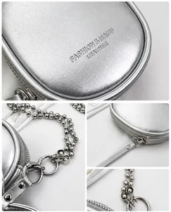 Detail of silver metallic mini pouch with chain strap and zipper closure for crossbody wear