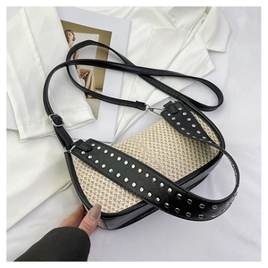 Détail du sac tissé avec rivets métalliques argentés et doubles bretelles en cuir