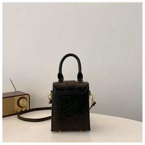 Detail of black wrinkled leather mini handbag with vintage gold metal hardware and studs