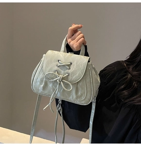 Dettaglio dello zaino stile balletto ciano chiaro con trama marmorea e fiocco intrecciato