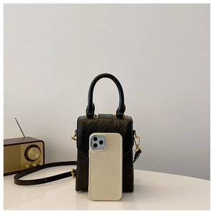 Mini black textured crossbody bag shown next to a smartphone for size comparison
