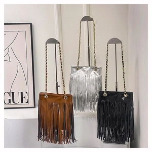 Vue détaillée de trois sacs à bandoulière à franges en marron, argent et noir avec chaînes