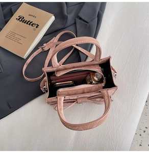 Top-down view of a light pink crossbody bag showing interior capacity and zipper pocket