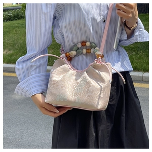 Gros plan détaillé du sac à main jacquard rose avec motifs de paysage et anses en perles