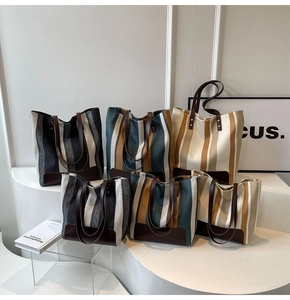 Detailed view of striped canvas tote bags in various sizes with premium leather trim