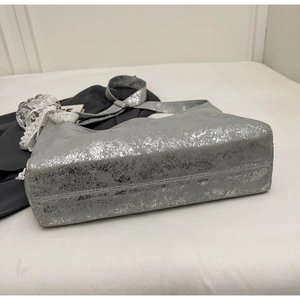 Detail showing the silver cracked metallic texture and soft hobo shape of the bucket bag