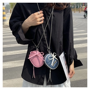 Mini bolsos bandolera de cuero rosa y denim azul con lazos decorativos y cadenas de bolas