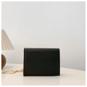 Close-up of black crossbody bag featuring lychee grain leather and gold chain strap