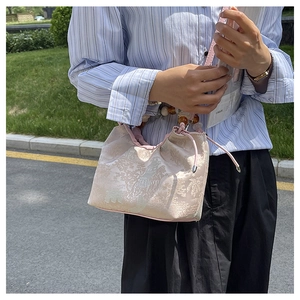 Vue détaillée du tissu jacquard beige avec motifs de jardin oriental et perles ambrées