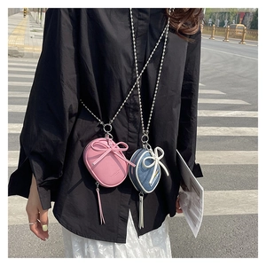 Minibolsos bandolera en cuero rosa y denim azul con lazos, borlas y cadenas plateadas