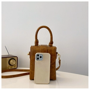 Brown mini crossbody bag shown with a smartphone for precise size comparison