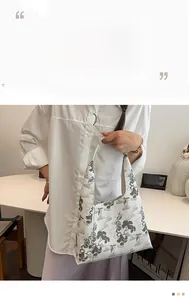 Detailed view of white bucket bag featuring elegant grey pine tree ink painting patterns