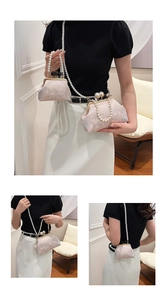 Detail view of pink floral jacquard embroidery and vintage pearl clasp on a qipao bag