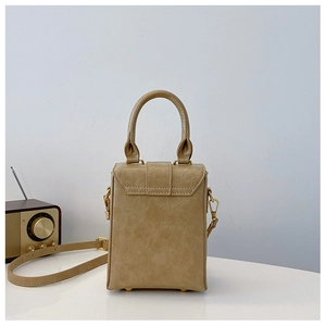 Detail of beige textured faux leather crossbody bag with gold hardware and strap