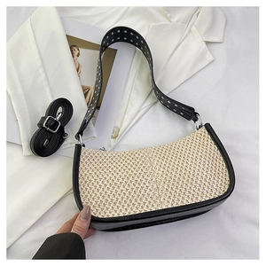 Détail du sac en paille en croissant avec bordure en cuir noir et bandoulière à rivets