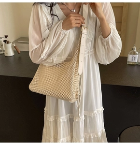 Detail of beige woven mesh handbag with premium leather strap and adjustable metal buckle