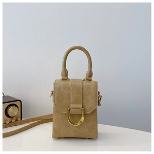 Detail view of khaki mini crossbody bag with golden horseshoe buckle and textured leather