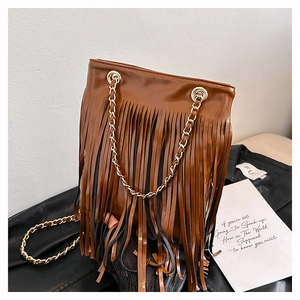 Détail du sac seau marron vintage avec de longues franges et une bandoulière dorée