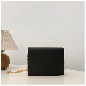 Side view of black lychee texture crossbody bag with elegant gold chain strap detail