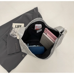 Top view of silver bucket bag interior showing large capacity with tablet and daily items