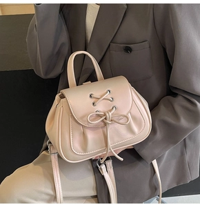 Dettaglio della borsa albicocca con fiocco, occhielli metallici e trama in pelle PU