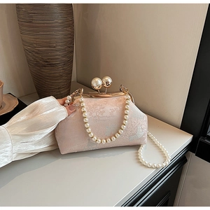 Detail of pink brocade qipao bag with dual pearl clasp and elegant pearl handle
