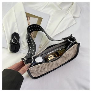 Vue détaillée du sac tressé avec rivets montrant l'espace pour téléphone et maquillage