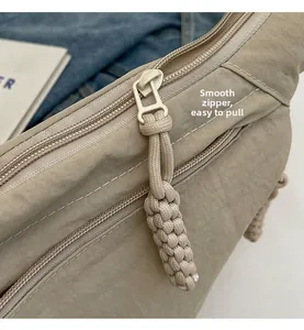 Gros plan sur la fermeture éclair lisse avec tirette en corde beige du sac nylon