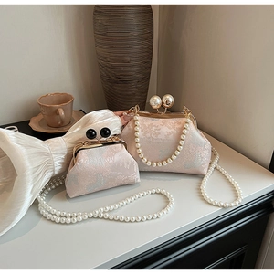 Detailed view of pink floral embroidery texture and premium pearl clasp on a vintage bag