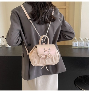 Vista dettagliata del mini zaino rosa con fiocco indossato sulla schiena della modella