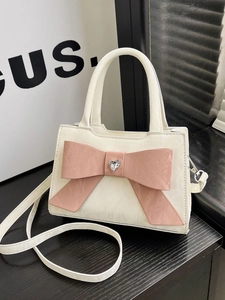 Elegant cream leather handbag with large pink bow and crystal heart charm