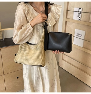 Detail of woven straw tote bag with black leather inner pouch and golden metal buckle
