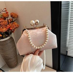 Detail of pink embroidered cheongsam bag with pearl clasp and vintage floral jacquard pattern