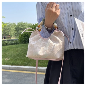 Détail d'un sac à main style chinois avec broderie paysage et poignée perlée