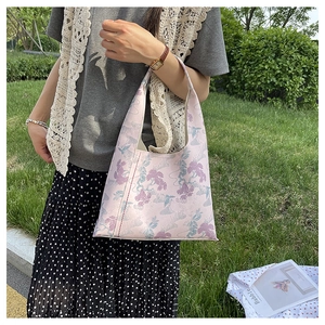 Detail of pink embroidered hobo bag with traditional Chinese pine patterns in nature