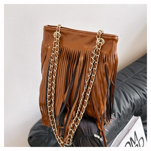 Détails d'un sac en cuir marron avec des franges denses et poignées en chaîne dorée