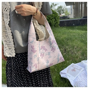 Model wearing a pink jacquard tote bag with vintage embroidery and floral patterns